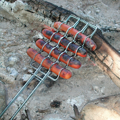 Roasting hot dogs over the fire
