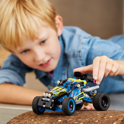 Boy playing with LEGO Technic Off Road Buggy