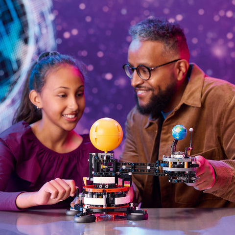 Girl showing dad LEGO Planet Earth & Moon in Orbit model kit