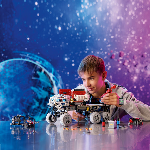 Boy playing with a LEGO Mars Crew Exploration Rover
