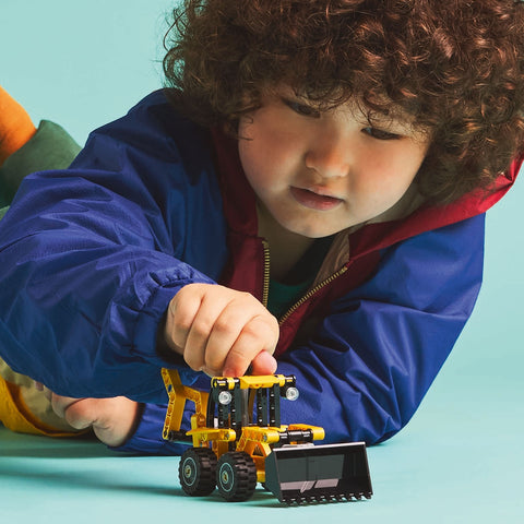 Boy playing with LEGO Technic Backhoe Loader 42197