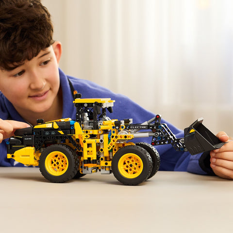 Boy playing with the LEGO Technic Volvo L120 Electric Wheel Loader Construction Toy 42209