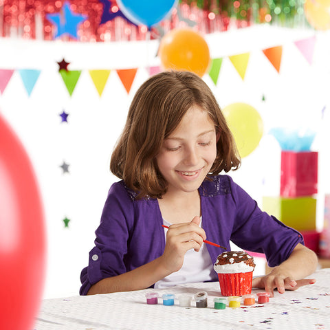 girls decorating cupcake at party