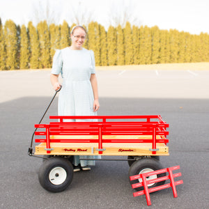 Large red wagon with woman standing next to wagon