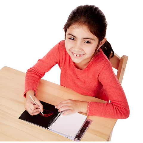 Girl using scratch art pad