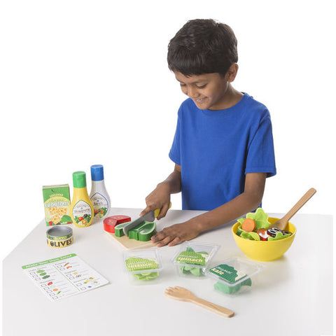 Child using toy salad set.