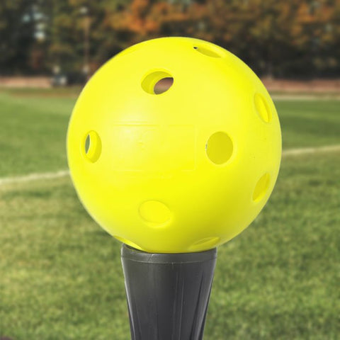yellow softball sitting on a tee