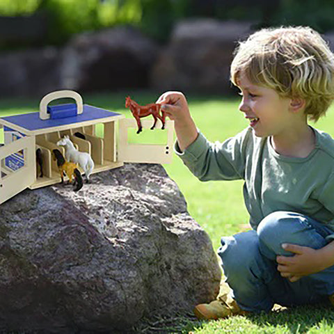 child playing with Breyer Farms stable