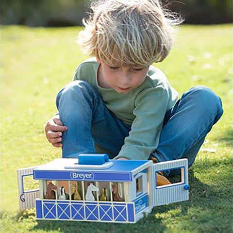 child playing with Breyer Farms stable