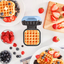 Blue Plastic Mini Waffle Maker RMW001GBSK06 displayed with waffles and fruit 