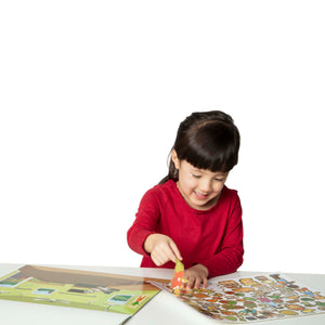 child peeling sticker on reusable farm set