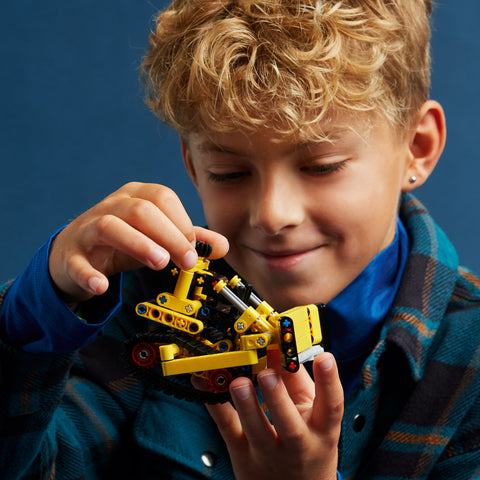 Boy holding LEGO Technic Heavy Duty Bulldozer