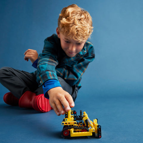 Boy playing with LEGO Technic Heavy Duty Bulldozer