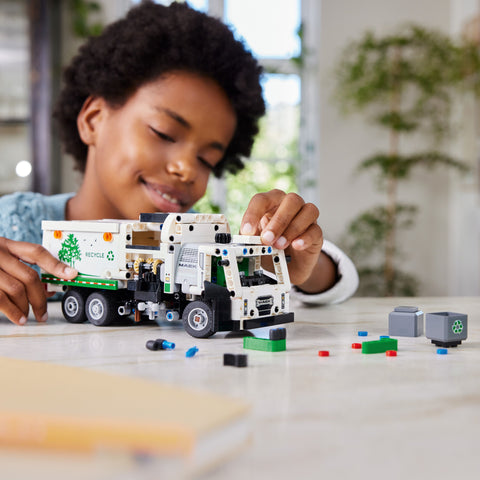 Boy playing with LEGO Technic Mack LR Electric Garbage Truck