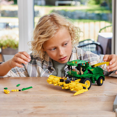 Child assembling LEGO Technic John Deere 9700 Forage Harvester