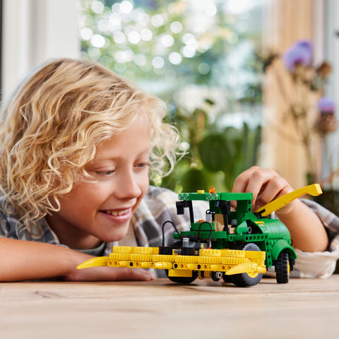 Child playing with LEGO Technic John Deere 9700 Forage Harvester