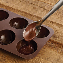 Hot cocoa bomb molds showing chocolate being filled
