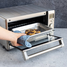 Person Putting Pan in Compact Oven