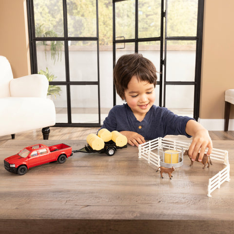 Little boy playing with Tomy Ertl 1:32 scale Truck & Hay Trailer Farm Toy Set