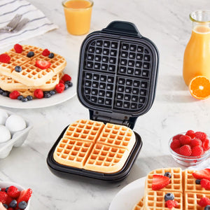 Black Plastic Mini Waffle Maker REWM7100GBBK06 displayed with waffles and fruit