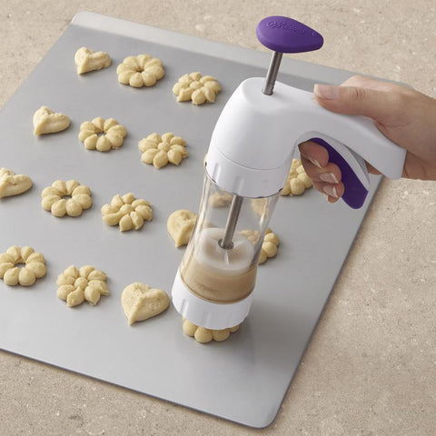 Simple Success Cookie Press 191001676 being used to press cookies unto baking sheet