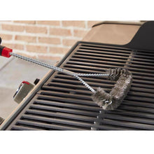 Weber 18-inch three-sided Grill Brush in use on grill grate