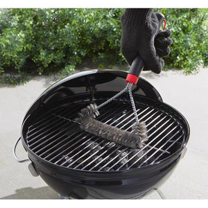 Weber 12-inch three-sided Grill Brush being used on grill grate