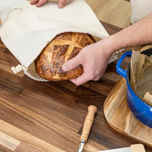 Person Putting Sourdough Bread in Bread Bag