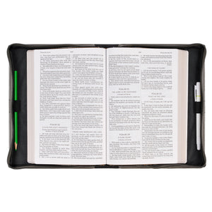 Bible cover open with Bible and pens inside