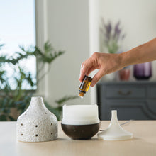 Adding essential oil to diffuser.