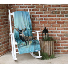 Deer throw on a white rocking chair in front of the intersection of two brick walls