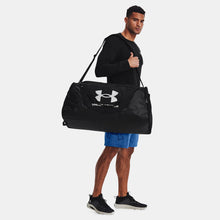 Man carrying Black Under Armour Undeniable 5.0 Duffle Bag on shoulder
