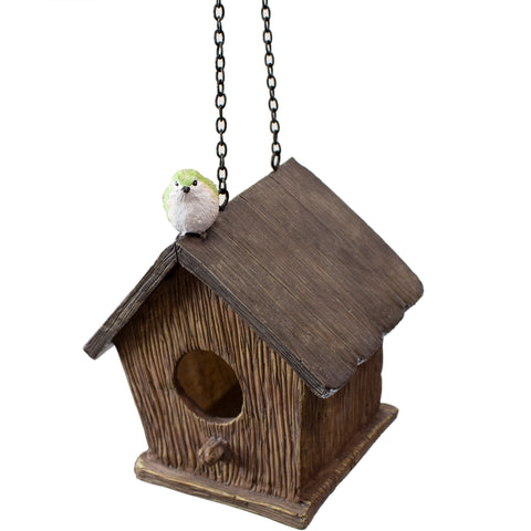 Birdhouse with a green bird perched on top