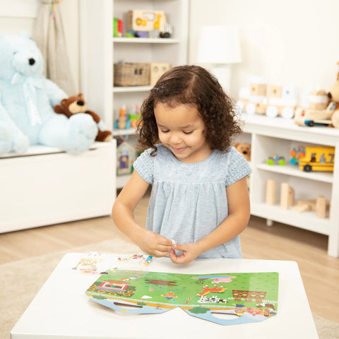 Girl playing with puffy sticker play set