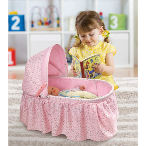 Little girl reading to doll in crable