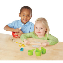 Boy and girl palying with baking set.