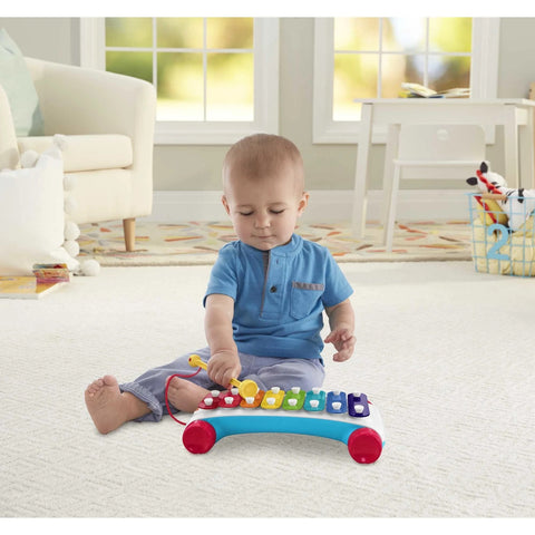Small boy playing with a Fisher Price Classic Xylophone toddler toy