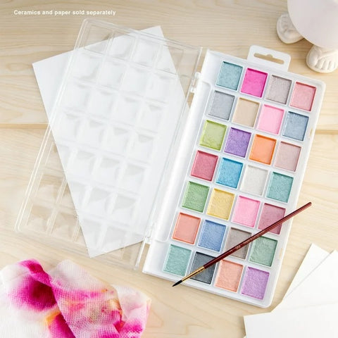 Watercolors and Brush Laid on Table with Paper