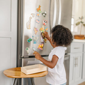 Child playing with magnets on refrigerator.