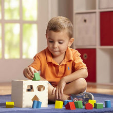 Shape sorting cube. Child playing.