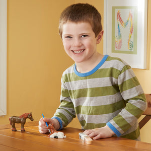 boy with horse figurines paint and brush