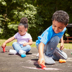 children using sidewalk chalk in holders