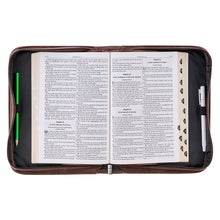 Bible cover open with Bible and pens inside