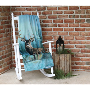 Deer throw on a white rocking chair in front of the intersection of two brick walls