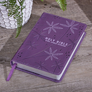 Bible laying on outdoor table with plant