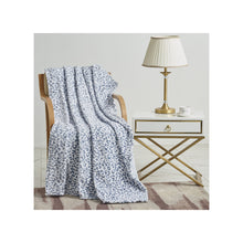Plush Leopard Animal Print Throw draped over chair next to an end table with lamp