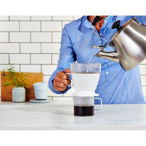 Woman pouring water over Mr Coffee maker