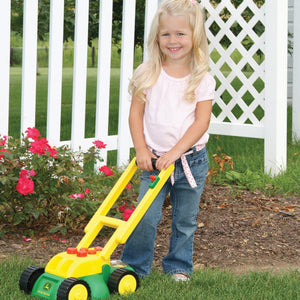 Little girl pushing lawn mower