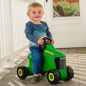 Toddler on toy John Deere tractor