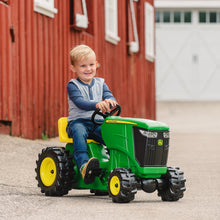 Boy driving pedal tractor